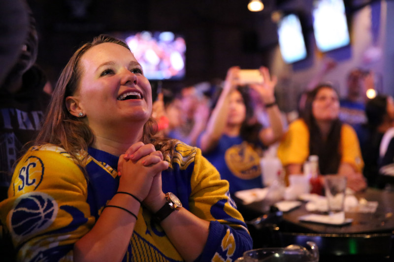 Fans bask in the glory of the Warriors championship at The Grand Oaks Sports Bar in Oakland. (Adam Grossberg/KQED)