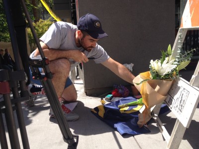 A man leaves flowers at an impromptu memorial for victims of Tuesday's balcony collapse in downtown Berkeley. 