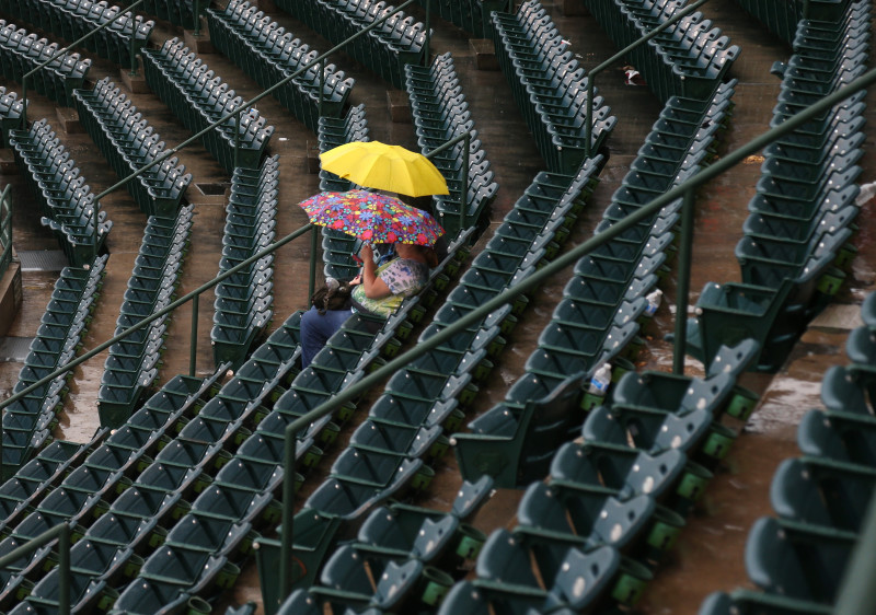 Fans with umbrellas sit in the stands in Anaheim, waiting for the start of the game between the Angels and Boston Red Sox. The game was postponed -- the Angels' first rainout in 20 years.  