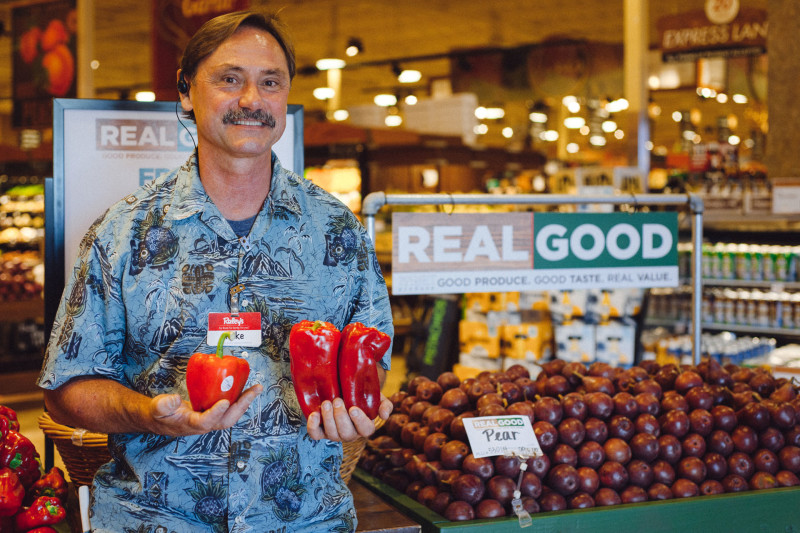 Mike Selepec, produce team leader at Raley's, holds a $2 "perfect" red pepper next to "imperfect" peppers, which sell for $1.19 per pound.