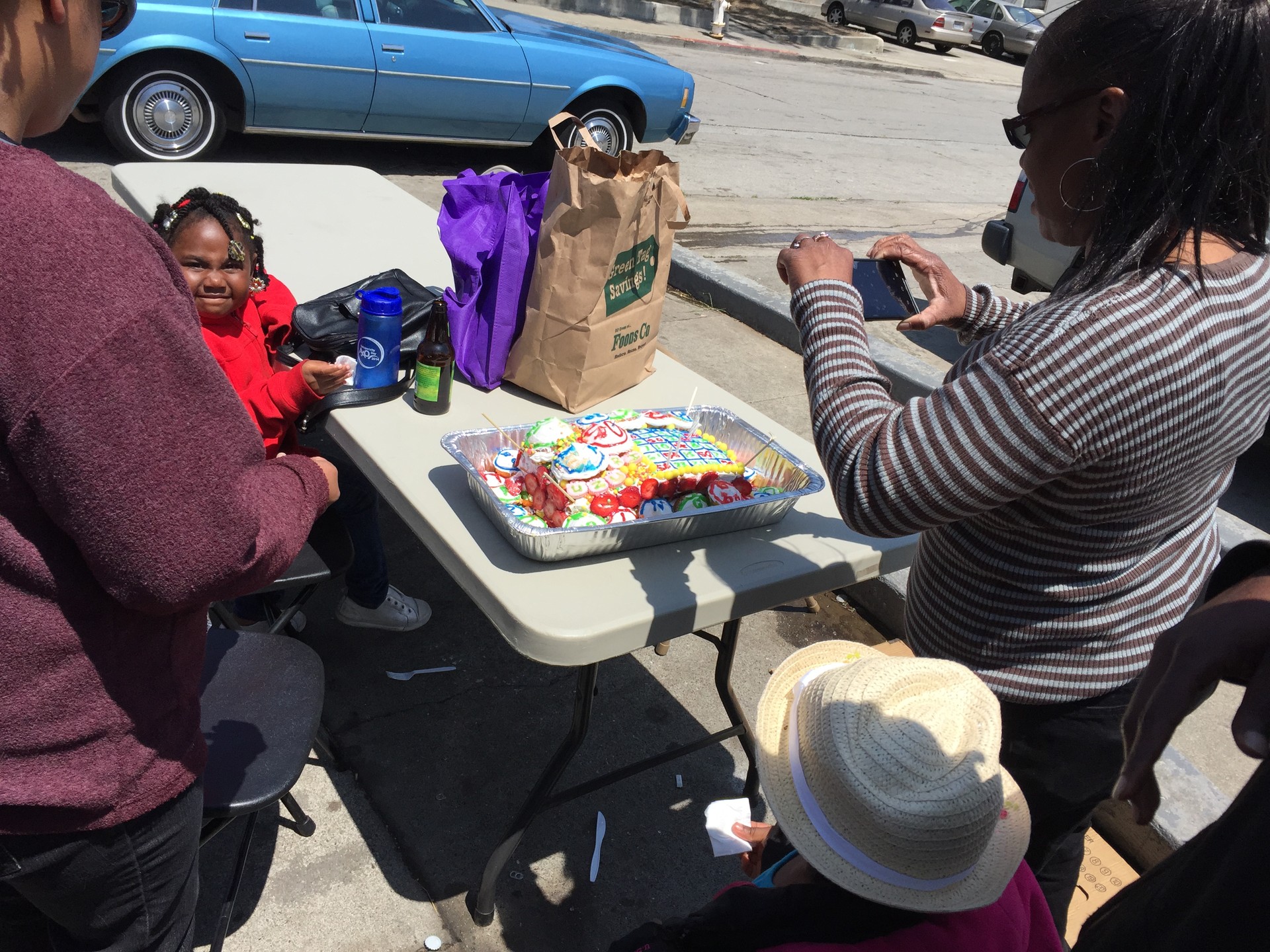 Residents admire a 'Bingo'-themed birthday cake on display at a July 26 barbecue in Potrero Terrace.