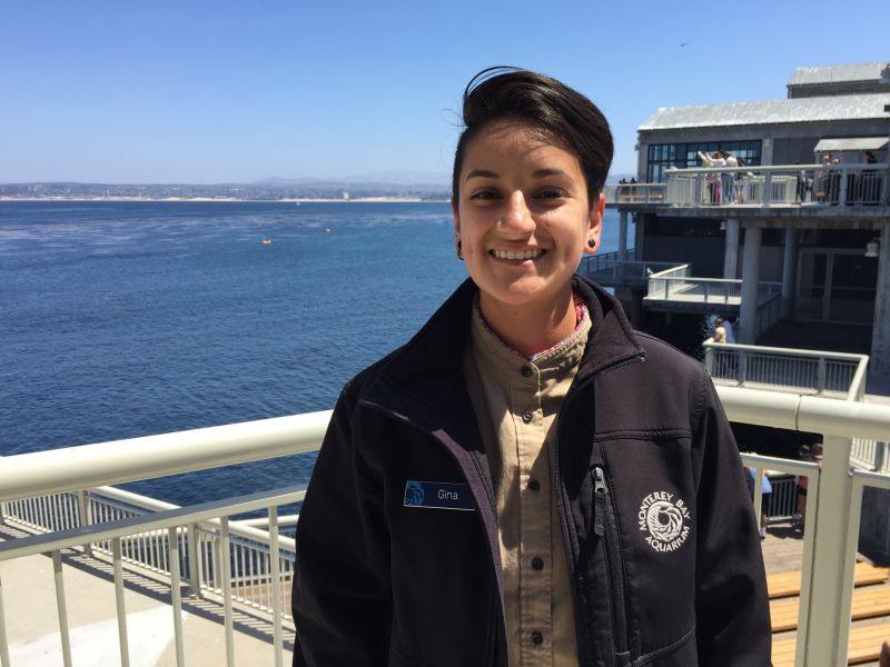 Gina Carrillo stands on a balcony at the Monterey Bay Aquarium overlooking the Monterey Bay.  In high school, Carrillo participated in the Watsonville Area Teens Conserving Habitats  program. Now she works for the Aquarium.