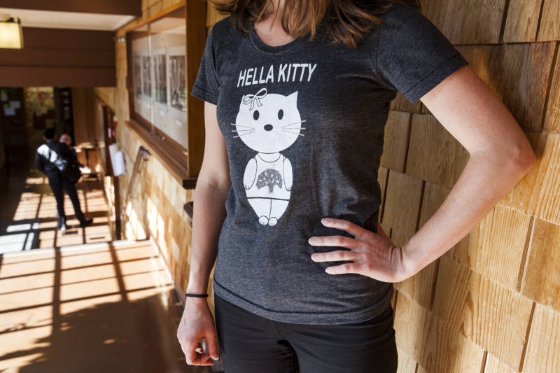 A UC Berkeley student poses for photos wearing a 'Hella Kitty' shirt from Pure 510, a local custom t-shirt business in Oakland, California.