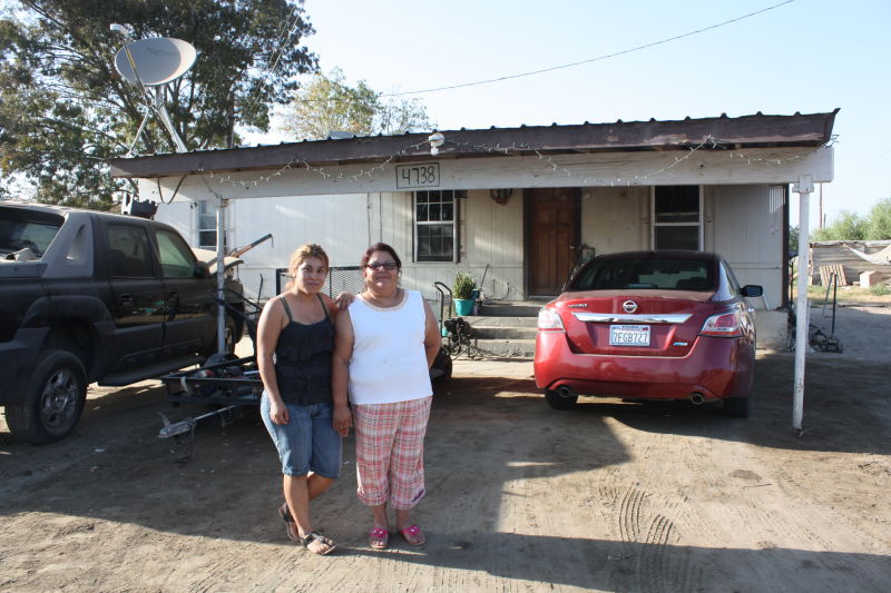 Maria Medina, right, and her 20-year-old daughter Guadalupe outside their Okieville house, where they haven’t had running water for 18 months.