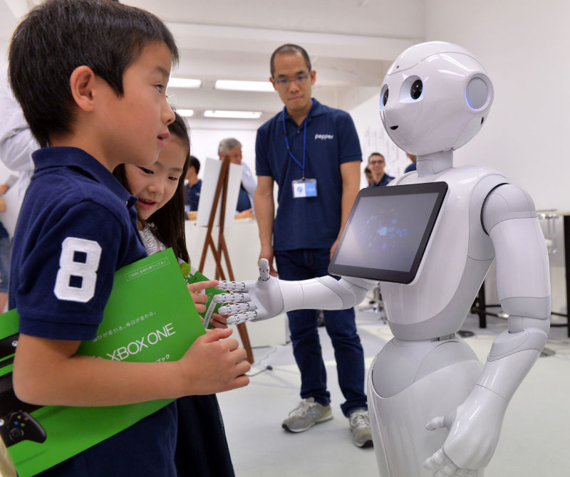 The humanoid robot Pepper chats with children at a high-tech gadgets exhibition in Tokyo.