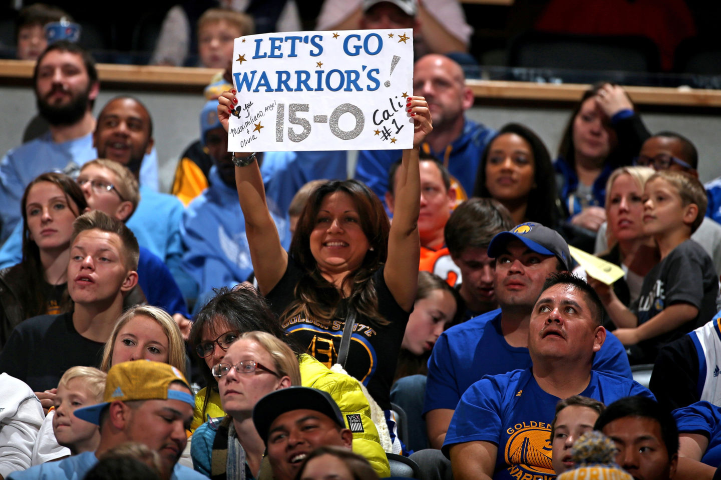 Fans celebrate the Golden State Warriors 15-0 season start with their 118-105 victory over the Denver Nuggets. (Doug Pensinger/Getty Images)