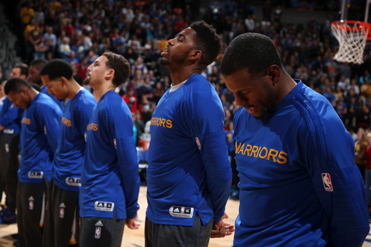 Andre Iguodala (R) and his teammates observe the national anthem prior to facing the Denver Nuggets Nov. 22, 2015. (Doug Pensinger/Getty Images)