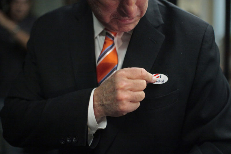 Governor Jerry Brown puts on an "I voted" sticker after casting his ballot at the Alameda County Registrar of Voters Office in Oakland, Calif. on Thursday, Oct. 30, 2014.