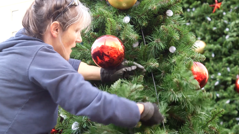 Lights and decorations are placed on the tree segments before they are stacked together.