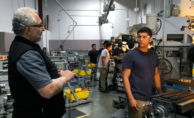 Professor Philip Yaghmai (left) talks to Ismael Becerra, 18, in the lab at El Camino Community College's Compton campus. Students translate machining theory into practice on vertical mills, CNC machines and other heavy equipment used in aerospace fastener manufacturing.