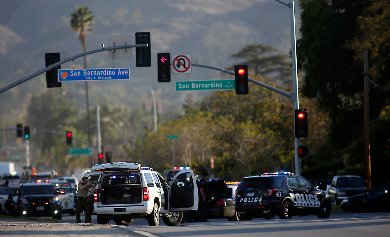 Police draw guns on San Bernardino Avenue while chasing suspects in an SUV. Later, police said alleged shooters Syed Farook, 28, and Tashfeen Malik, 27,  were killed in a shootout with police