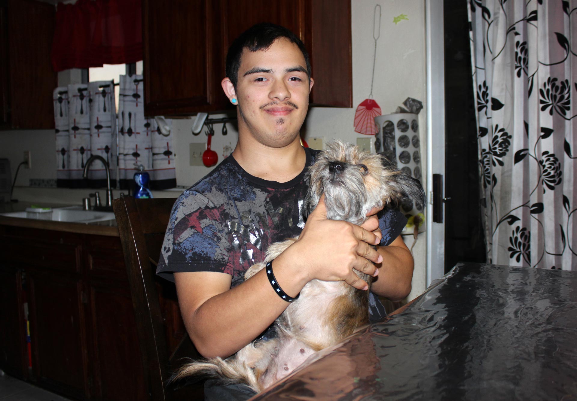 Christian Roldan, 18, holds his dog at home. He has Down syndrome and can respond to questions only with one or two-word replies. He was hogtied and arrested in 2013 for resisting a school police officer’s attempts to search him at the Chino Valley Unified School District. 