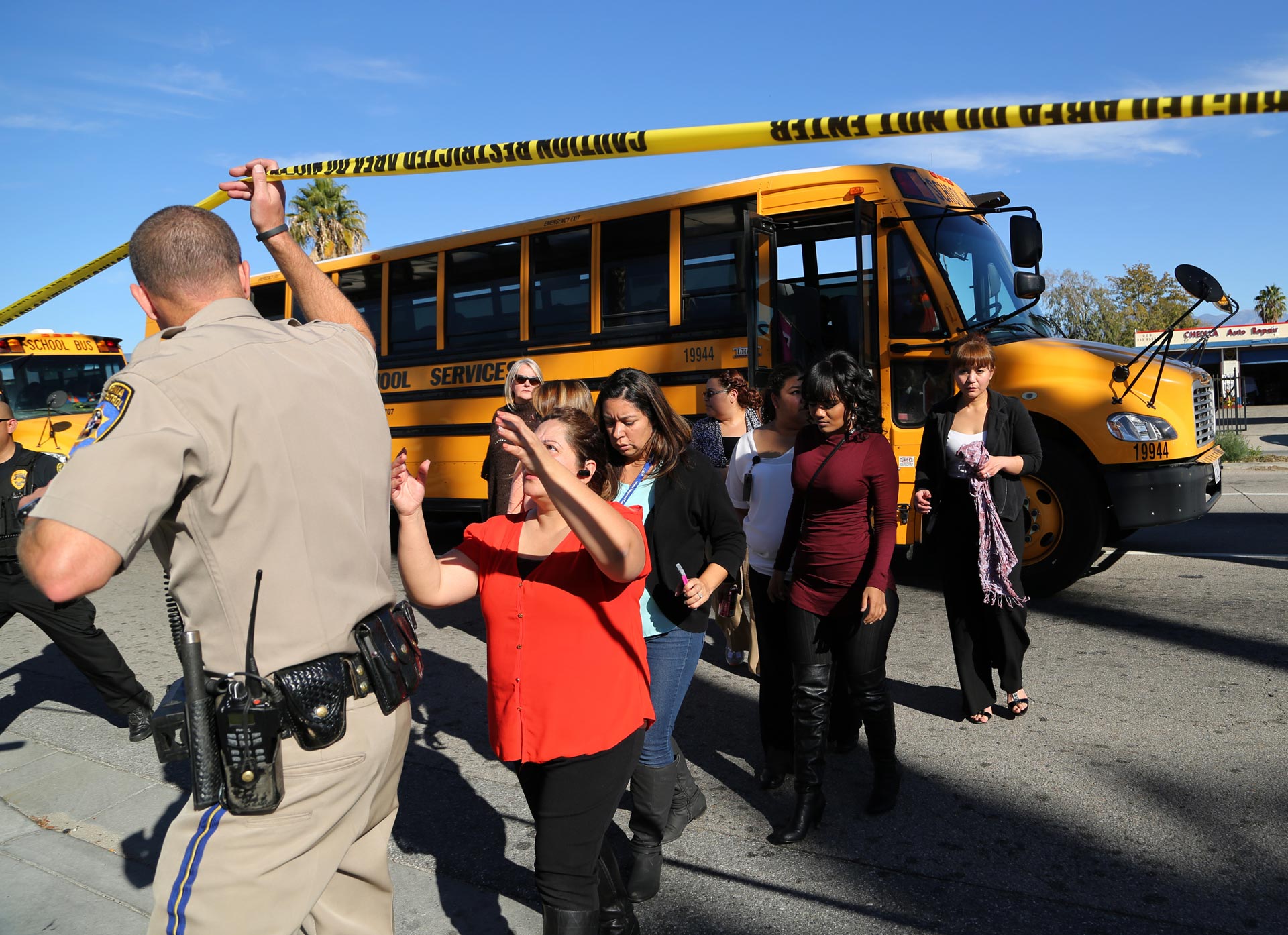 Employees and others are evacuated by bus from the site of a mass shooting at the Inland Regional Center in San Bernardino.