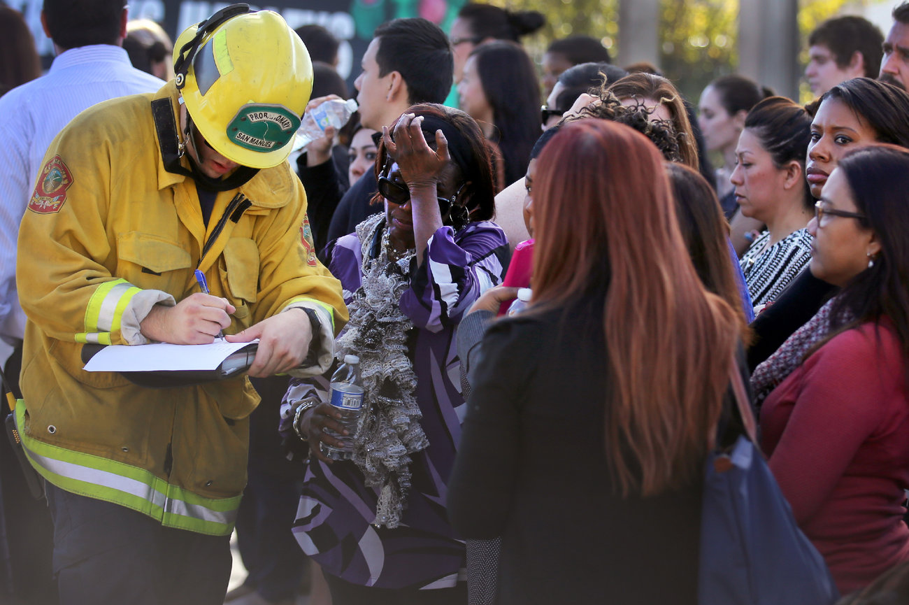 A member of the San Manuel Fire Department takes the names of people being evacuated after the shooting.