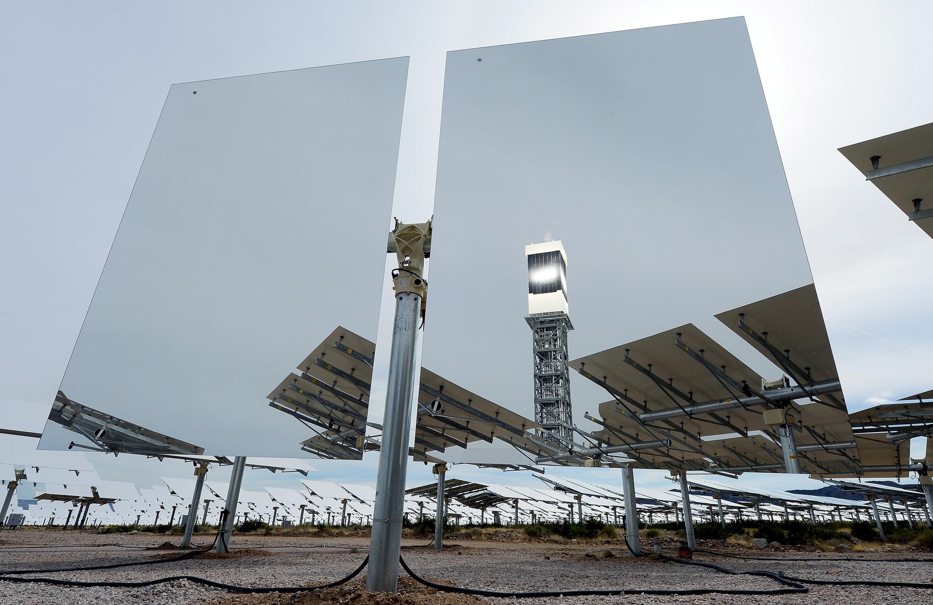 A solar receiver and boiler on top of a tower is reflected in a heliostat with two mirrors at the Ivanpah Solar Electric Generating System.