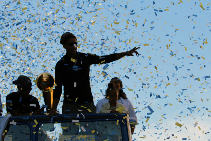 Stephen Curry rides through Oakland with the NBA Championship trophy during the Warriors Championship parade. (Adam Grossberg/KQED)