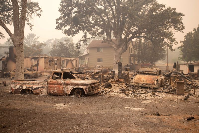 Burned out vehicles are surrounded by smoldering rubble as firefighters continued to battle the Valley fire in Middletown, California.