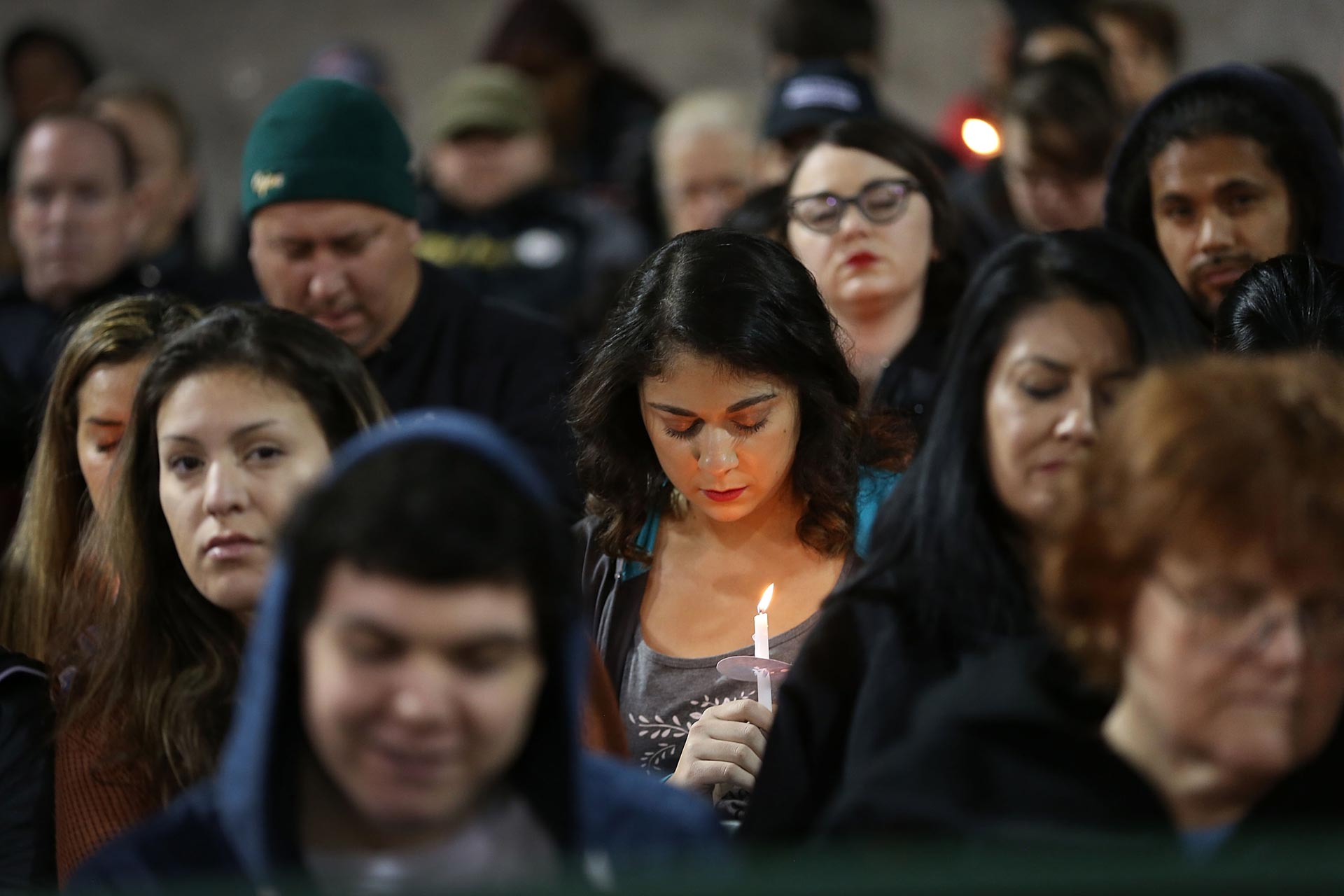 People hold candles as they attend a vigil at the San Manuel Stadium to remember those injured and killed during the shooting at the Inland Regional Center on Dec. 3, 2015 in San Bernardino.