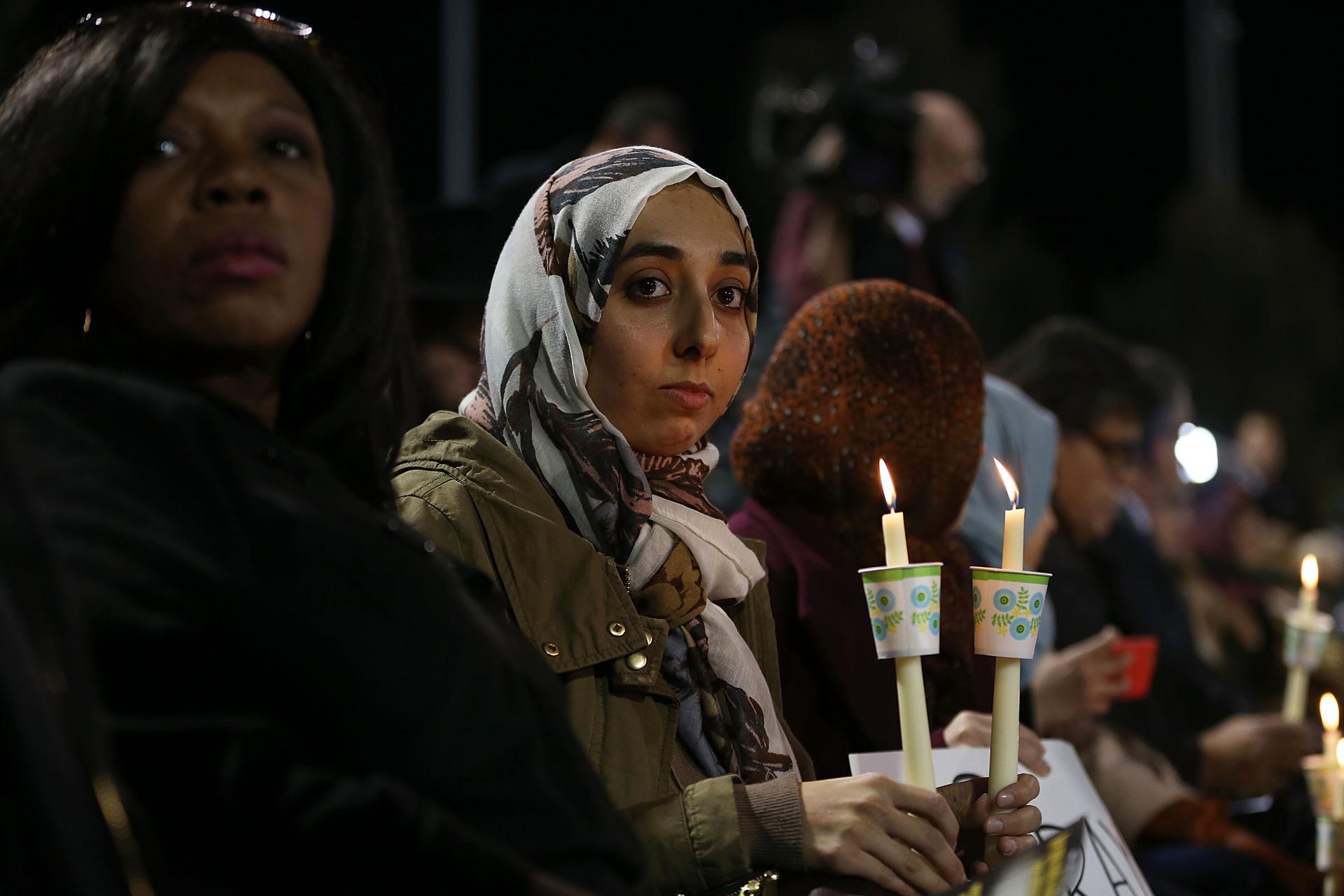 People hold candles as they attend a vigil at the San Manuel Stadium to remember those injured and killed during the shooting at the Inland Regional Center on Dec. 3, 2015 in San Bernardino.