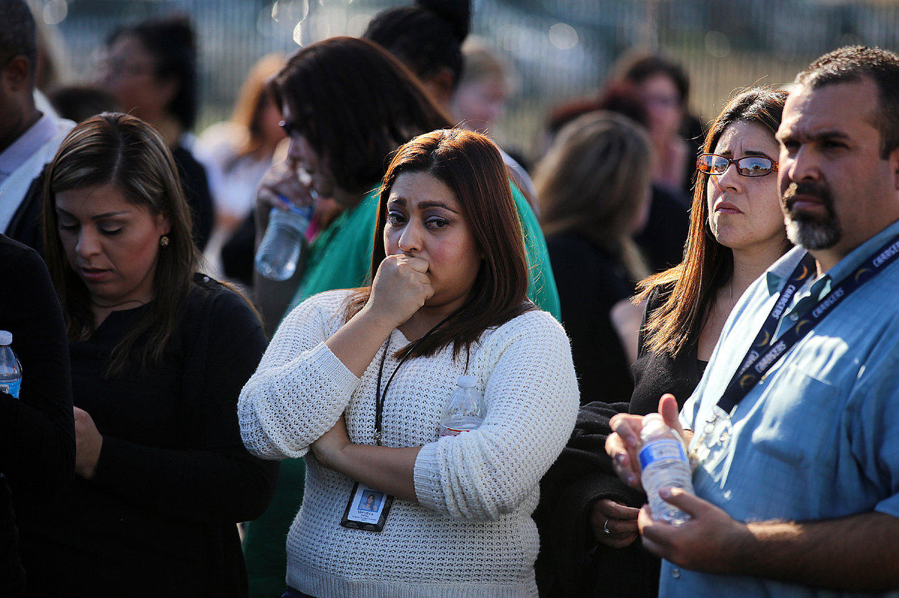 Workers wait to be evacuated by bus as police search for suspects on Wednesday, Dec. 2 in San Bernardino.