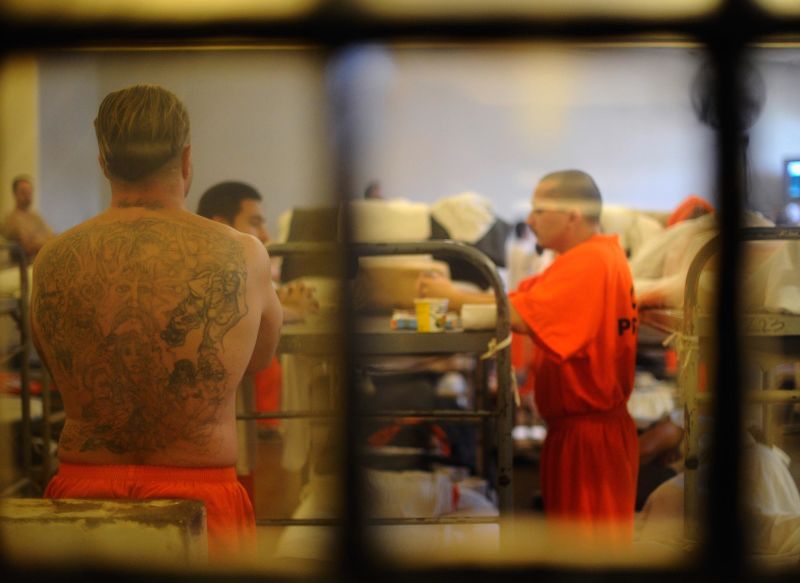 Inmates at Chino State Prison walk in between their double bunks in an overcrowded dayroom that was modified to house prisoners in 2010. At the time, more than 144,000 inmates were incarcerated in prisons that were designed to hold about 80,000.