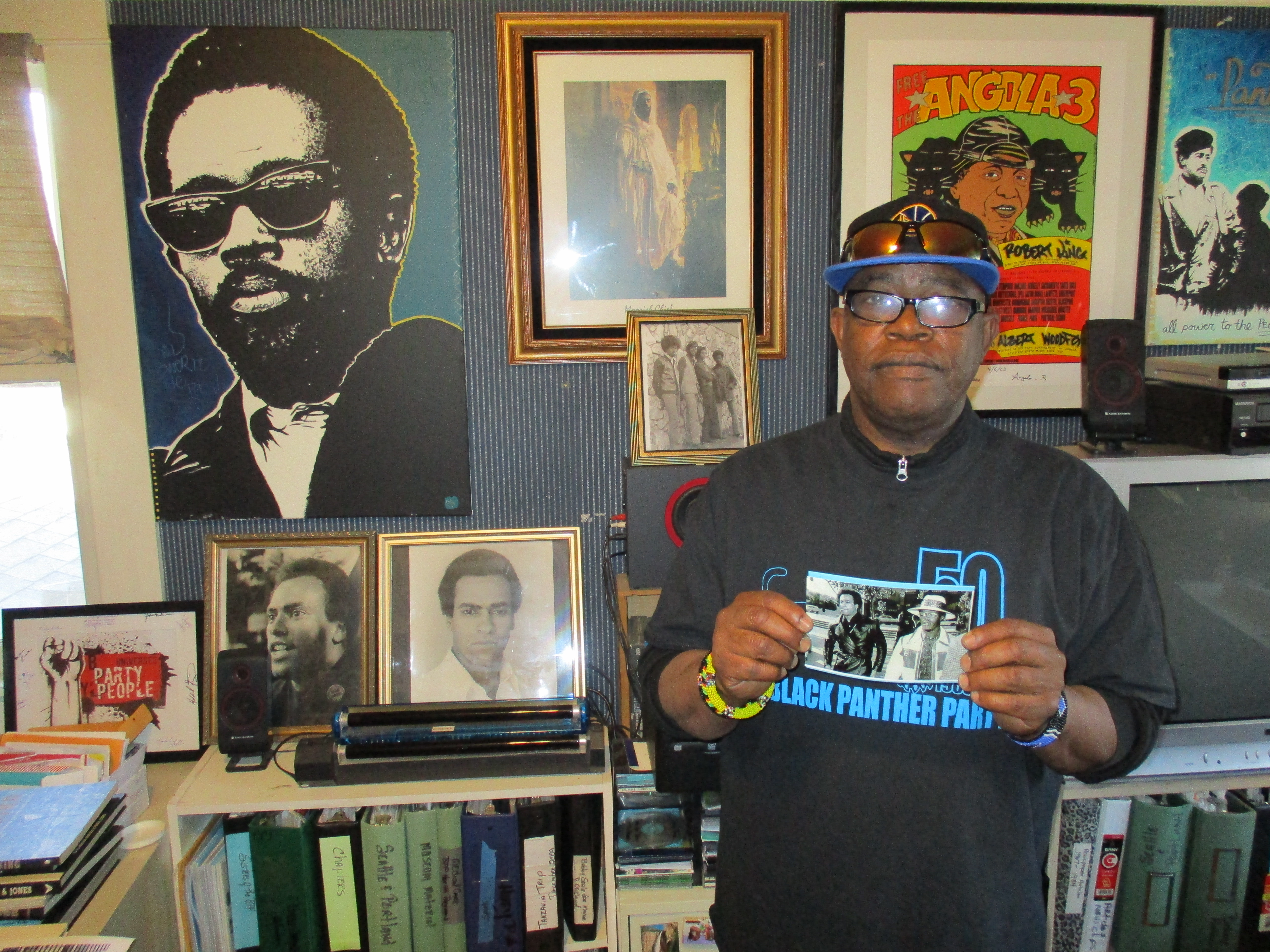 Billy X Jennings holding up a picture of him with Black Panther Party leader Huey Newton. 