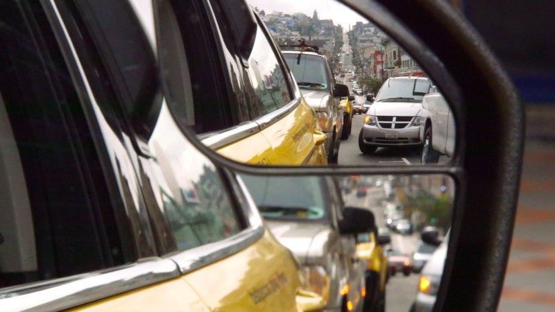 Looking back through one of the sideview mirrors on John Han's taxicab. (Adam Grossberg/KQED)