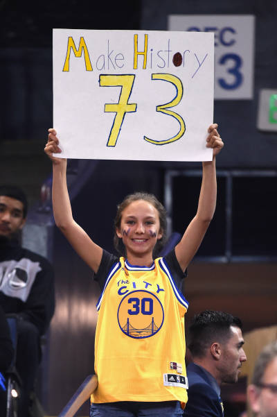 A Golden State Warriors fan holds a sign as the team appears to be closing in on win #73. (Thearon W. Henderson/Getty Images)