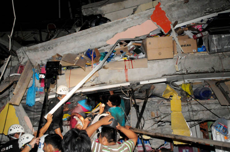 Rescue workers struggle to extricate people trapped  in a collapsed building  in the coastal city of Manta, Ecuador after a huge earthquake struck Saturday evening. 