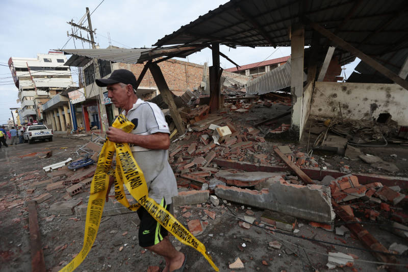 A man walks next to rubble at a street after a 7.8-magnitude quake in Portoviejo, Ecuador. 
