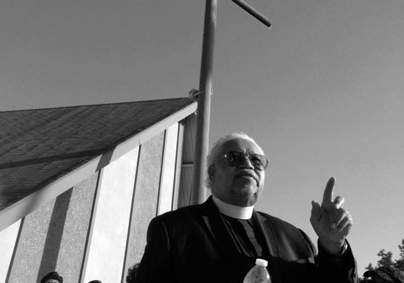 The Rev. Norman Copeland of St. Paul A.M.E Church in San Bernardino speaks to residents gathered for a peace vigil and march.
