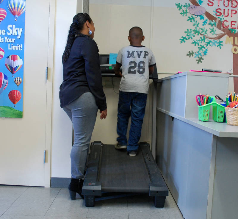 Danielle Martin helps a student use a treadmill in Room 30 at Oak Ridge Elementary School. The treadmill is used on a daily basis for kids to release stress and refocus their energy.