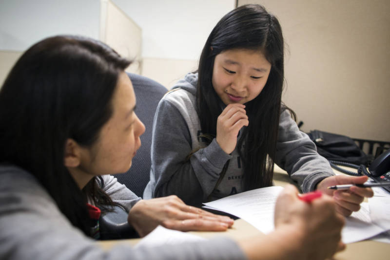 Lia Kim, a Korean teacher at the Los Angeles Center for Enriched Studies, works with ninth-grader Nara Hong on a call script in Korean during a phone bank shift reminding people to vote in the upcoming primary election at Asian Americans Advancing Justice Los Angeles on May 23, 2016. The students are volunteering through the K.W. Lee Center for Leadership.