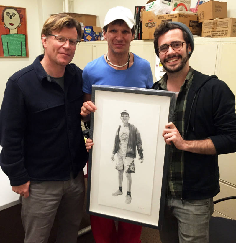 George Arthur poses with reporter Michael Montgomery (L) and artist Joel Daniel Phillips (R), who holds the portrait he drew of George.