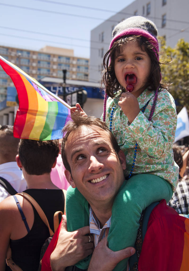 Father and daughter watch this years's San Francisco Pride Parade. 