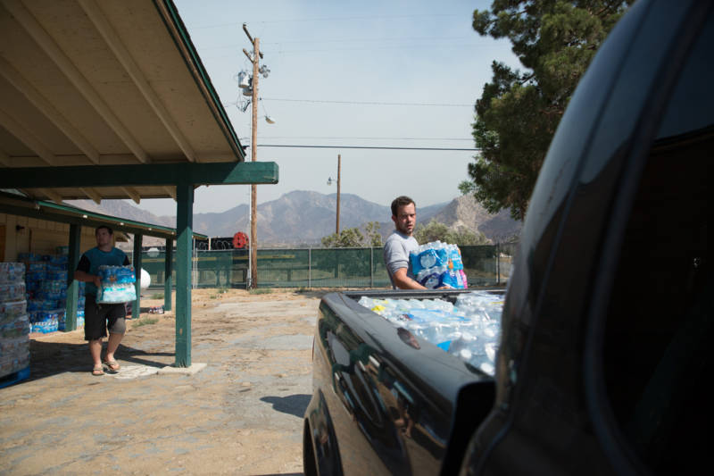Chris Carstens (left) and Justin Gammeel (right) restock supplies. They use their military identification cards to move freely within the evacuation zones, delivering water to residents who stayed behind. 