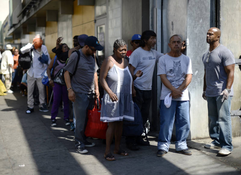 A homeless woman waits in line to receive groceries and clothing from Los Angeles-based non-profit My Friend's House Foundation September 23, 2015, in the skid row section of Los Angeles, California. 