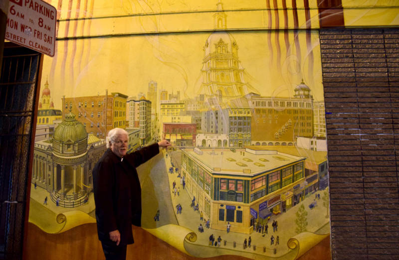 Minister Lyle Beckman points out where we are on an intricate mural depicting the ghosts of churches leaving the Tenderloin. With them often go services rendered to the poor and homeless in the area. 