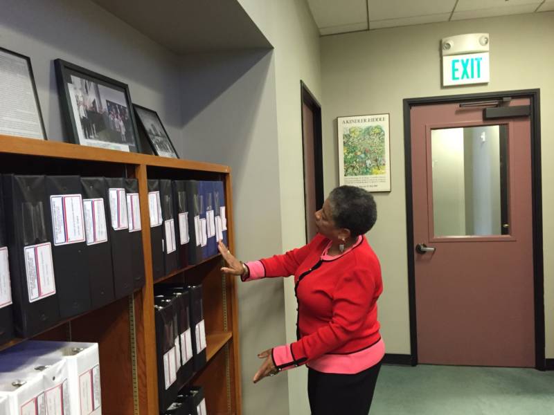 OCC Executive Director Joyce Hicks peruses binders filled with complaint summary reports.