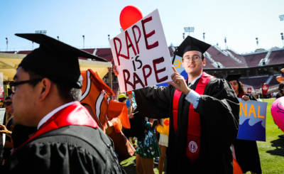 Stanford student Paul Harrison carries a sign in a show of solidarity for the victim in the Brock Turner case during graduation ceremonies at Stanford University on June 12, 2016.