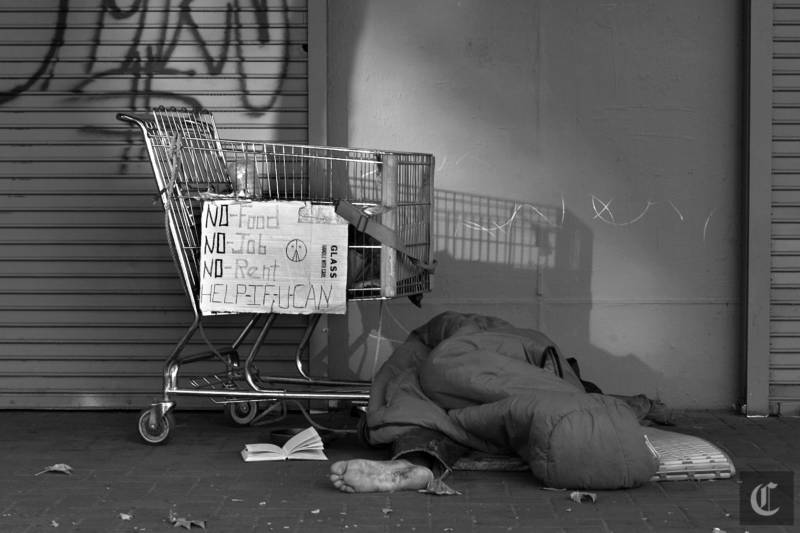 A homeless person sleeps on Market St. in San Francisco.