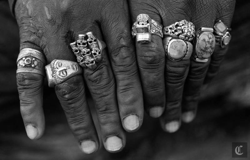 A homeless man shows his rings he has collected over the past 5 years. He spends his days sitting in the branches of an Australian Tea Tree reading books and taking with passers by in Golden Gate Park. 