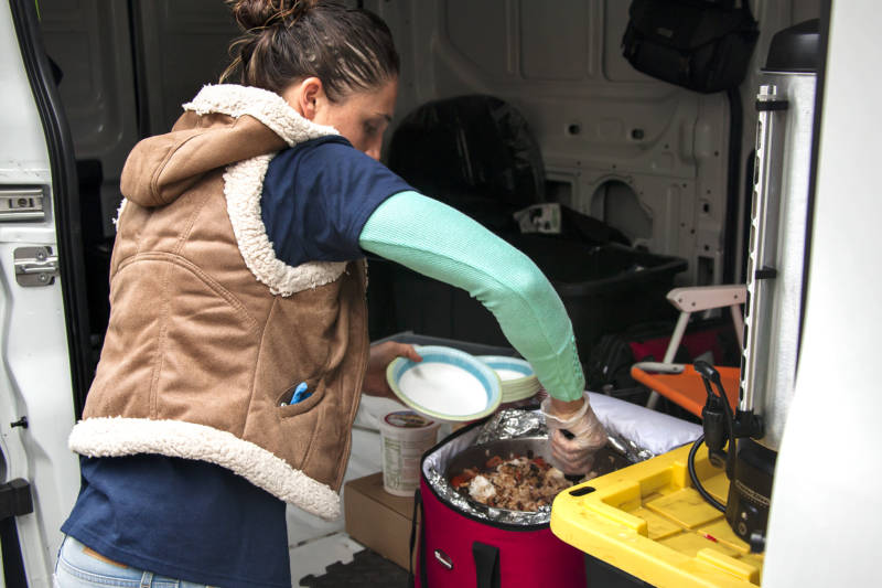 Ashley Blair Thomas, serves the night’s dinner to the local homeless that come to the relief center.
