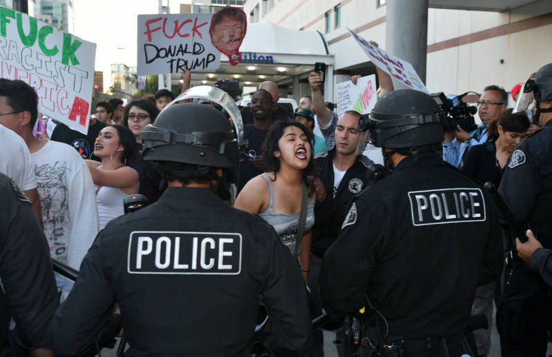 A woman yells at San Jose police officers during a protest near where Republican presidential candidate Donald Trump held a rally on June 02, 2016.