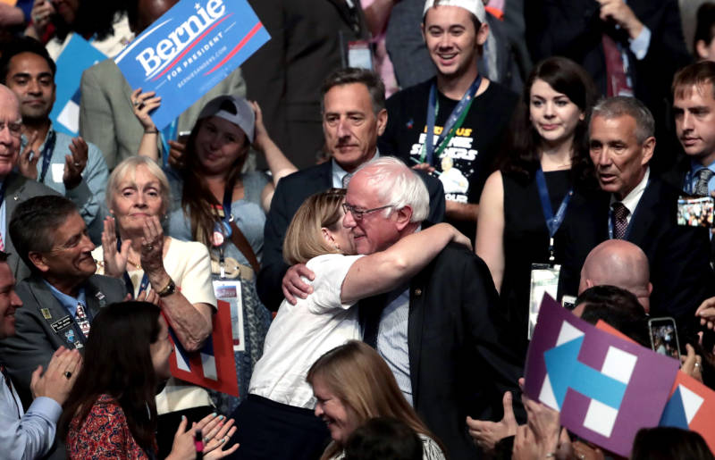 Sen. Bernie Sanders hugs an attendee during roll call on the second day of the Democratic National Convention.