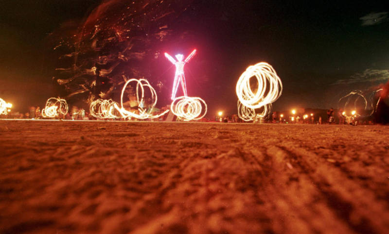 Dancers at 1998's Burning Man festival create patterns with fireworks.