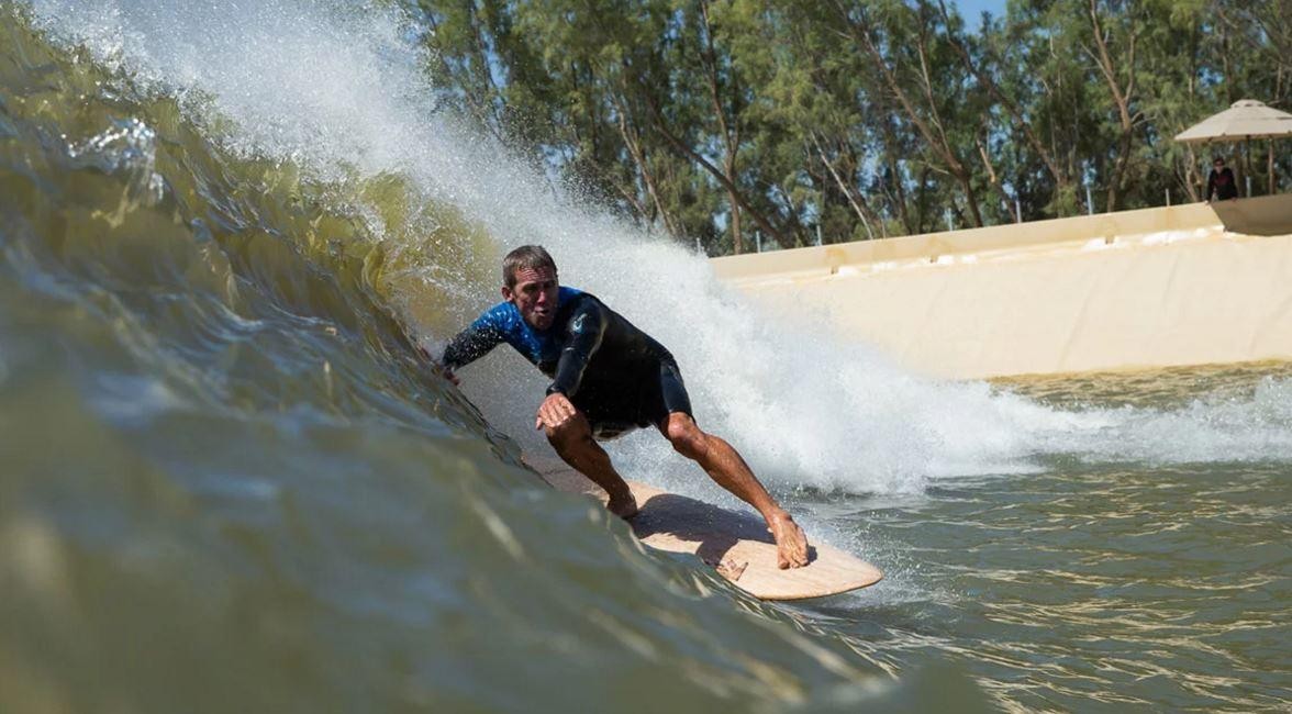 A surfer rides a longboard at the secret wave spot.