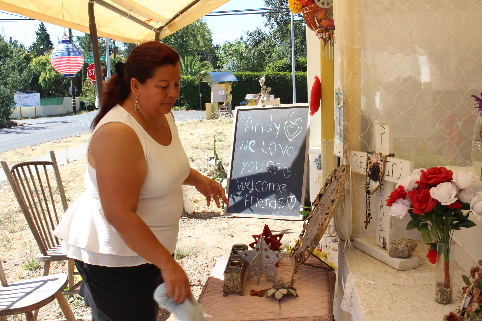 Concepcion Dominguez cleans a memorial for Andy Lopez on July 26, 2016 at the site of his death on a lot he used to play in. Dominguez, a former neighbor of Lopez's, says she would prefer Gelhaus be kept off street patrol. "It's too dangerous" for residents,
