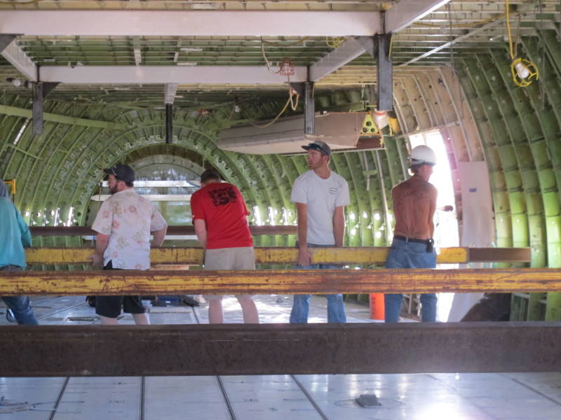 747 Project creator Ken Feldman (Hawaiian shirt), workers and volunteers help place beams that will help transport the plane to Burning Man.