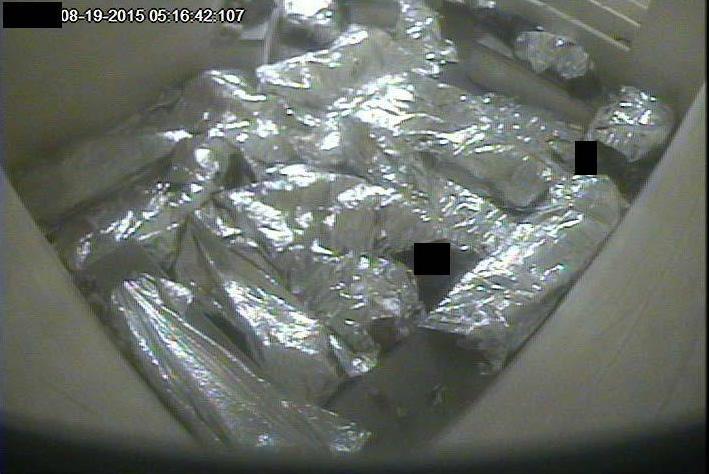 Detained immigrants, wrapped in Mylar sheets, lie crowded together on concrete floors and benches in a cell in Tucson in August 2015.